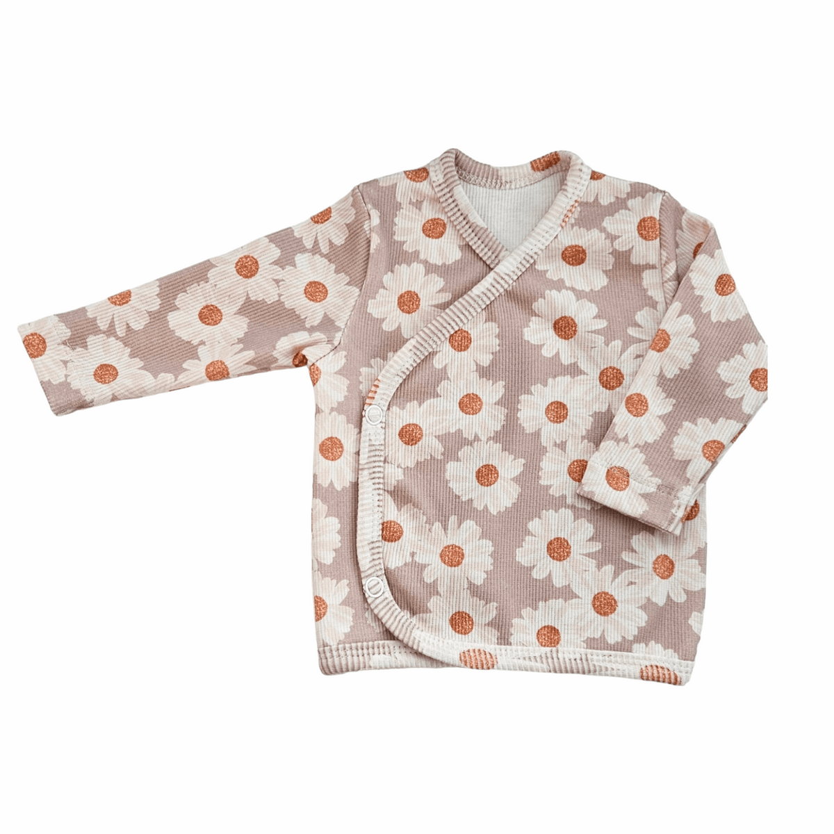 Een vredige pasgeboren baby gehuld in een Overslagshirt Daisy Delight gemaakt van katoen OEKO TEX en bijpassende hoofdband, comfortabel genesteld in een knus wiegje, symbool voor de pure onschuld en sereniteit van Yumi Baby.