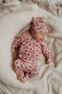 Baby meisje slapend in een maan kussen met een roze bloemen pakje aan